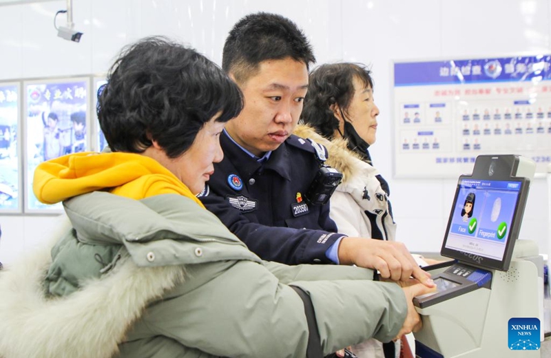 A police officer helps a South Korean tourist scan fingerprint at the arrival hall of the international passenger terminal of Lianyungang Port in Lianyungang City, east China's Jiangsu Province, Dec. 28, 2025. A total of 255 South Korean tourists arrived in Lianyungang aboard the Harmony Yungang cruise ship, commencing a five-day New Year tour in China. This marks the largest group of South Korean travelers received at Lianyungang port passenger terminal since China's visa-free policy for South Korean citizens. (Photo by Wang Jianmin/Xinhua)