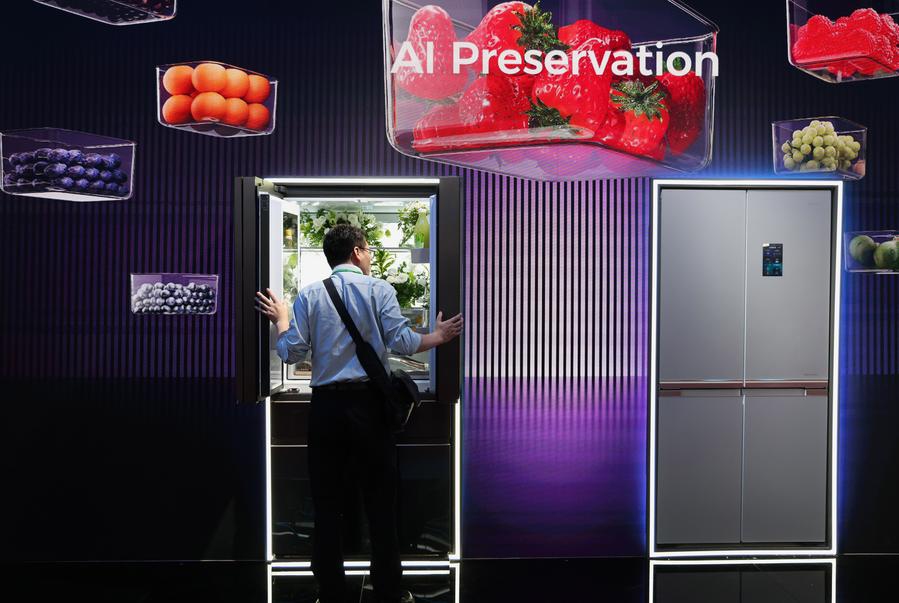 A buyer learns about an intelligent refrigerator during the 137th edition of the China Import and Export Fair in Guangzhou, south China's Guangdong Province, April 16, 2025. (Xinhua/Lu Hanxin)