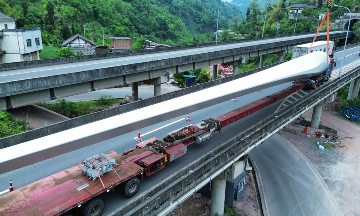 Blades for the Wushan Dafengkou wind power project are hoisted and transported from an expressway viaduct. Photo: Courtesy of China Three Gorges Corporation