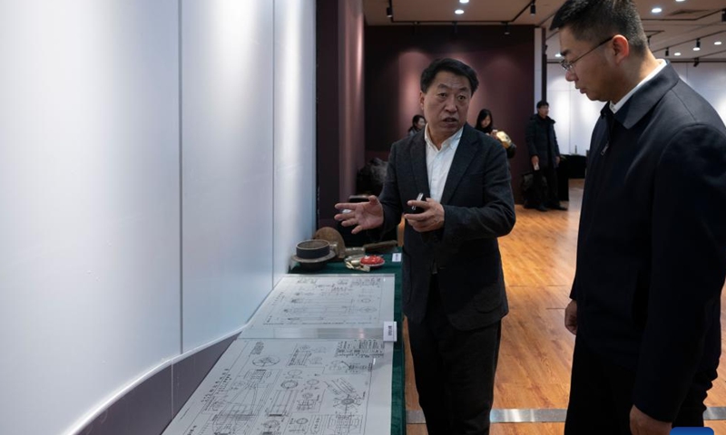 Jin Chengmin (L), curator of the Exhibition Hall of Evidence of Crimes Committed by Unit 731 of the Japanese Imperial Army, introduces exhibits at a special exhibition of social donation of cultural relics and historical materials at the exhibition hall in Harbin, capital of northeast China's Heilongjiang Province, on Dec. 31, 2025. The opening ceremony of the special exhibition was held here on Wednesday. (Xinhua/Zhang Tao)