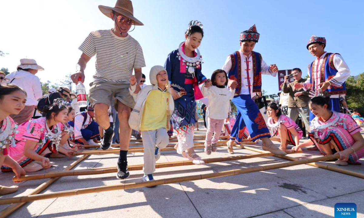 Tourists enjoy bamboo pole dance at a scenic area in Sanya, south China's Hainan Province, Jan. 1, 2026. China's economy kicked off 2026 with robust momentum, as evidenced by bustling economic activity in the year's first days. (Photo by Chen Wenwu/Xinhua)