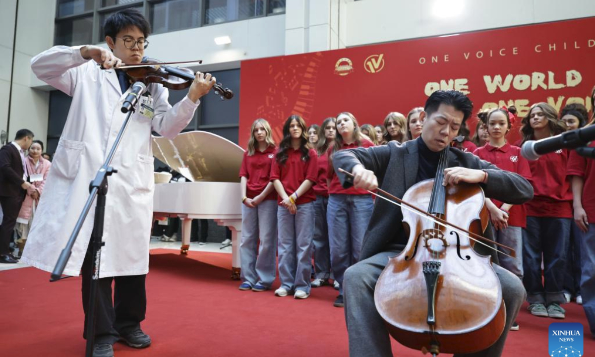 Ouyang Quanshi (L) from the Peking Union Medical College Hospital (PUMCH) and Feng Yao, the principal cellist of the Schleswig-Holstein Symphony Orchestra from Germany, perform at the PUMCH in Beijing, capital of China, Dec. 31, 2025. Fifty-six young performers from One Voice Children's Choir along with invited musicians gave a performance at the hospital on Wednesday. (Xinhua/Zhang Yuwei)