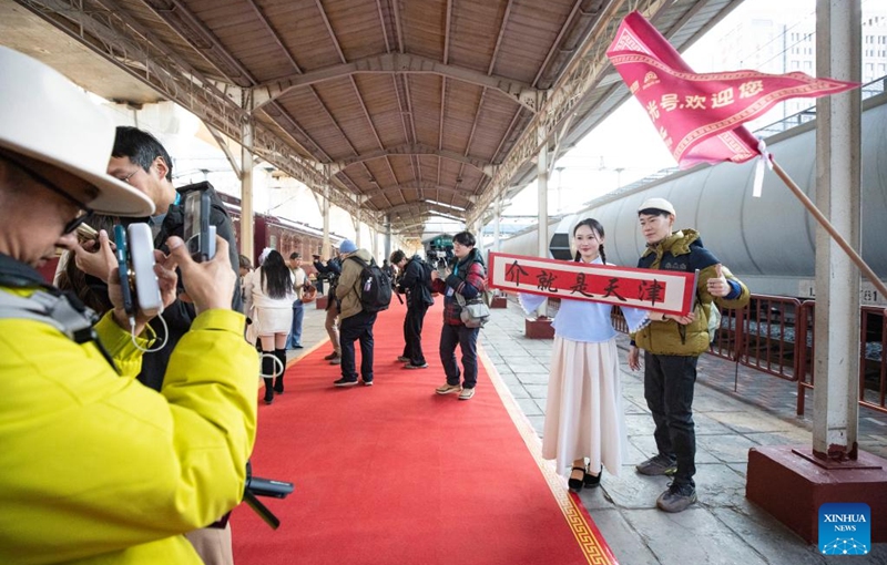 A tourist (1st, R) poses with a performer at the Tianjin North Railway Station in north China's Tianjin, Jan. 1, 2026. The Tianjin Fantasy Express has begun a scheduled round-trip service between Tianjin North Railway Station and Beijing Railway Station since Thursday. The line features 10 distinctively themed carriages integrating art performances, cultural presentations and intangible cultural heritage experience. Photo: Xinhua