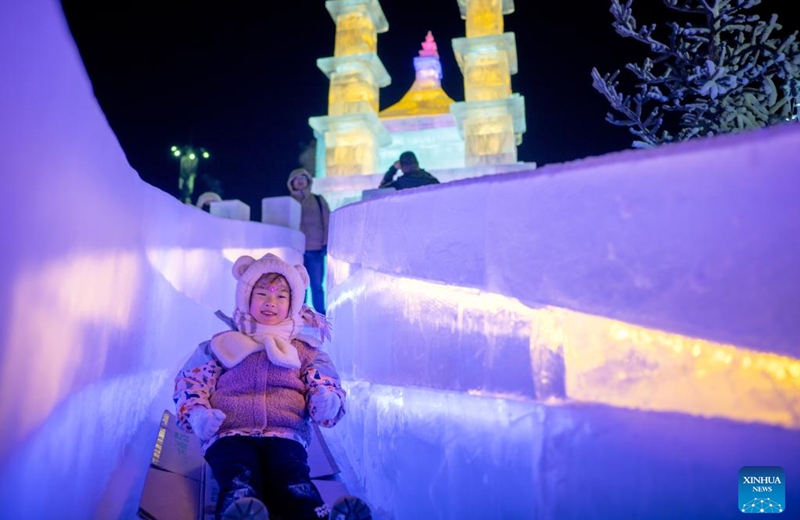 A child plays on an ice slide during an ice and snow festival at the Daheihe military cultural park in Hohhot, north China's Inner Mongolia Autonomous Region, Dec. 31, 2025. The event kicked off on Wednesday, attracting tourists to enjoy lanterns, ice sculptures and snacks. (Xinhua/Lian Zhen)