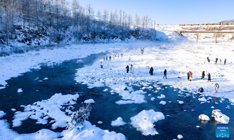 An aerial drone photo shows tourists having fun by the Halha River in the city of Arxan of Hinggan League, north China's Inner Mongolia Autonomous Region, Jan. 1, 2026. Despite Arxan's frigid winter cold, this geothermally-affected section of the Halha River never freezes, which attracts great amount of tourists in winter. (Xinhua/Ma Jinrui)