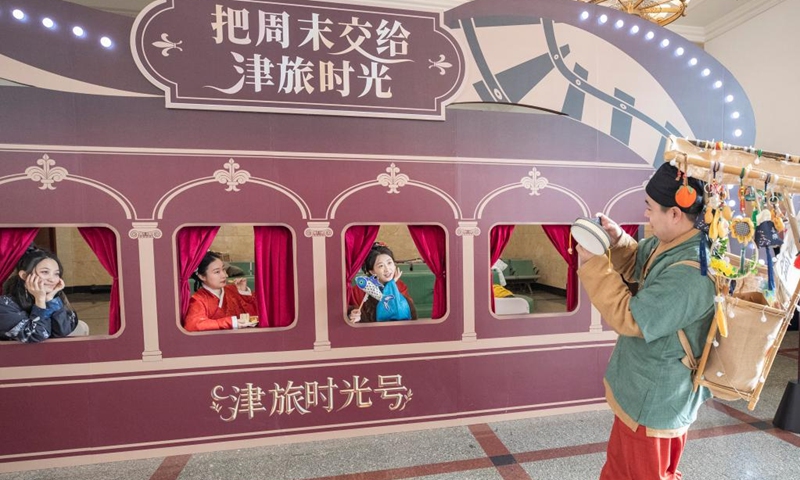 Tourists pose with a billboard at the Beijing Railway Station in Beijing, capital of China, Jan. 1, 2026. The Tianjin Fantasy Express has begun a scheduled round-trip service between Tianjin North Railway Station and Beijing Railway Station since Thursday. The line features 10 distinctively themed carriages integrating art performances, cultural presentations and intangible cultural heritage experience. Photo: Xinhua