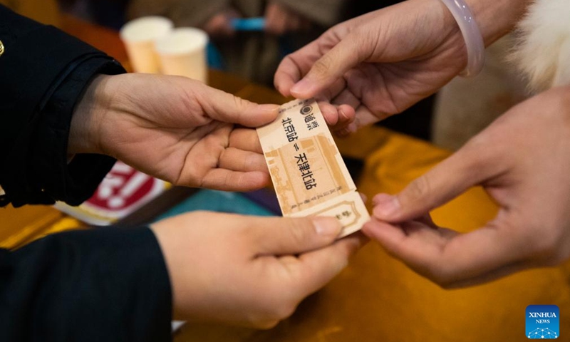 A staff member hands a commemorative ticket to a passenger at the Beijing Railway Station in Beijing, capital of China, Jan. 1, 2026. The Tianjin Fantasy Express has begun a scheduled round-trip service between Tianjin North Railway Station and Beijing Railway Station since Thursday. The line features 10 distinctively themed carriages integrating art performances, cultural presentations and intangible cultural heritage experience. Photo: Xinhua