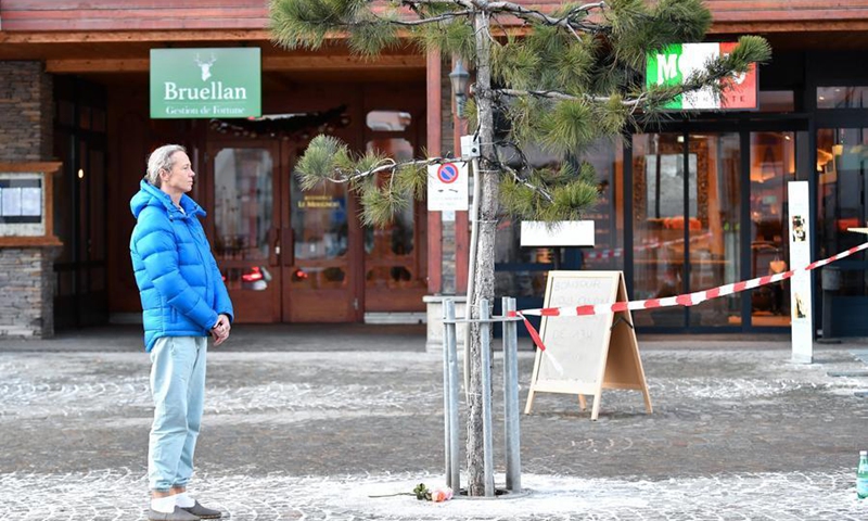 A woman mourns with flowers at the scene of a fire at a bar in the Crans-Montana ski resort in Valais Canton of southwestern Switzerland, Jan. 1, 2026. (Xinhua/Lian Yi)