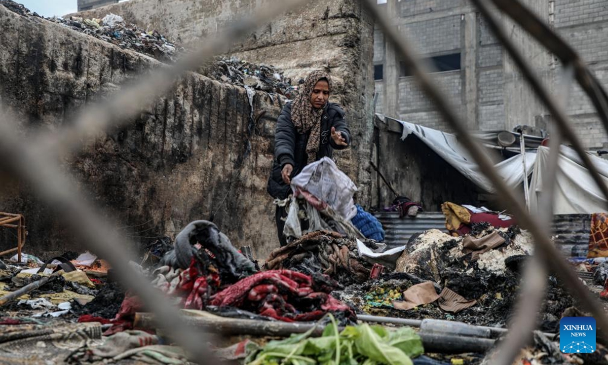 A displaced Palestinian woman inspects the damage to her temporary tent after a fire broke out the previous night, in Gaza City on Jan. 2, 2026. (Photo by Rizek Abdeljawad/Xinhua)