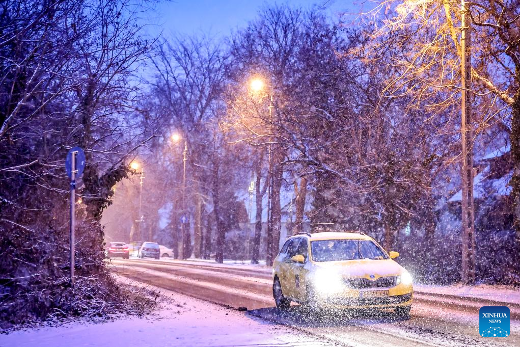 A car drives in the snow in Budapest, Hungary on Jan. 5, 2026. (Photo by David Balogh/Xinhua)