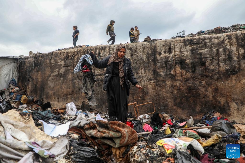 A displaced Palestinian woman inspects the damage to her temporary tent after a fire broke out the previous night, in Gaza City on Jan. 2, 2026. (Photo by Rizek Abdeljawad/Xinhua)