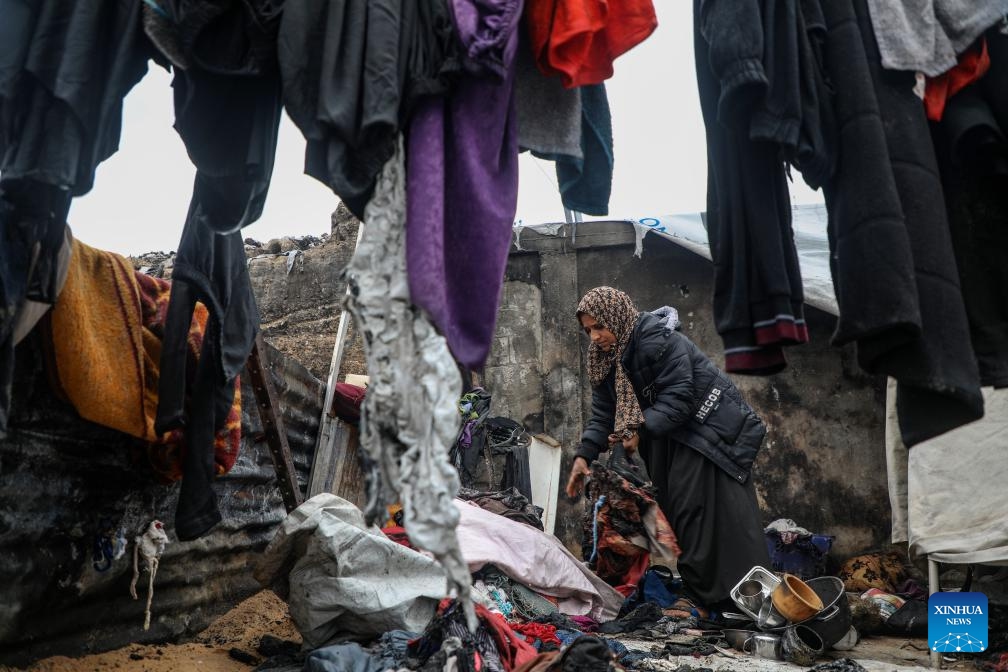 A displaced Palestinian woman inspects the damage to her temporary tent after a fire broke out the previous night, in Gaza City on Jan. 2, 2026. (Photo by Rizek Abdeljawad/Xinhua)