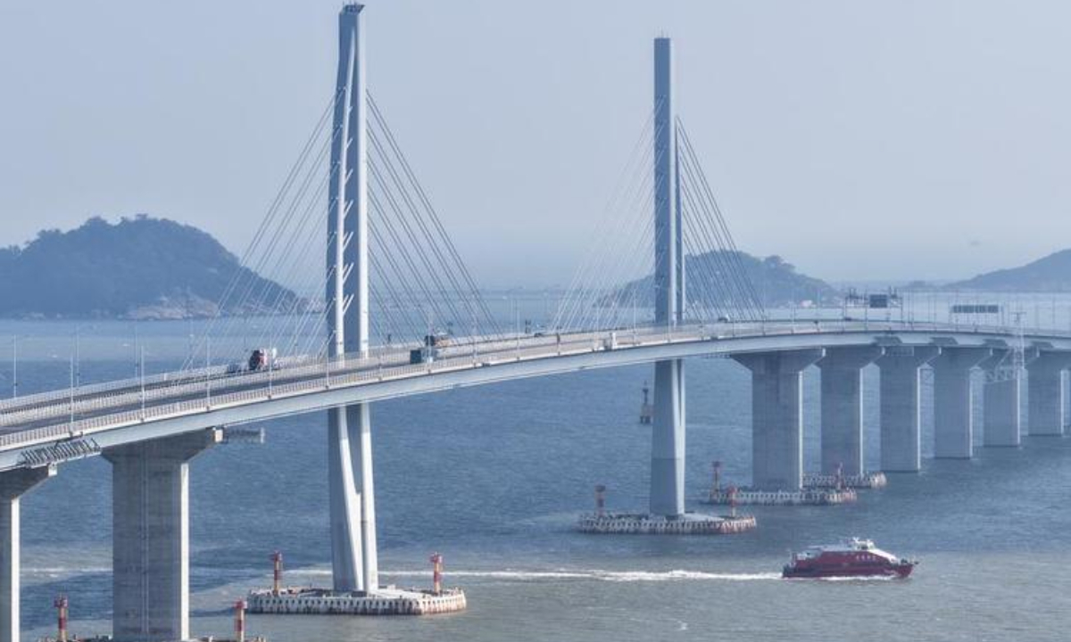 An aerial drone photo taken on Oct. 19, 2025 shows a cruise ship passing under the Hong Kong-Zhuhai-Macao Bridge in south China. (Xinhua/Deng Hua)