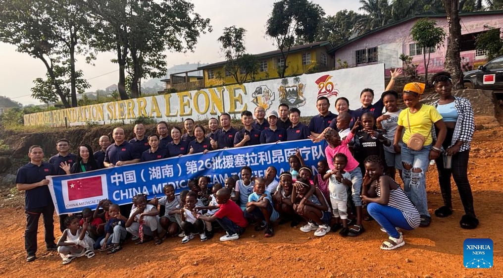 The 26th Chinese medical team to Sierra Leone poses for a group photo at the Saint George Foundation Children's Welfare Institute in Freetown, Sierra Leone, on Jan. 1, 2026. The 26th Chinese medical team to Sierra Leone on Thursday donated a batch of supplies as New Year gifts to a welfare home in Freetown, the country's capital. (The 26th Chinese medical team to Sierra Leone/Handout via Xinhua)