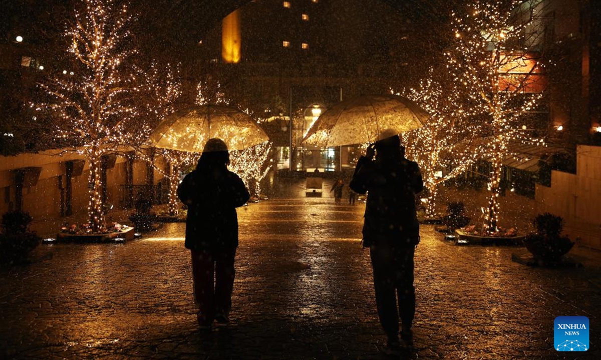 People walk on a street on the first snow day of 2026 in Tokyo, Japan, Jan. 2, 2026. (Xinhua/Jia Haocheng)