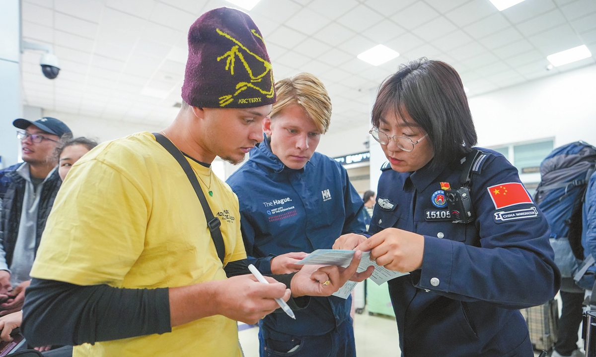 An immigration management police officer (right) provides customs clearance consultation for incoming travelers at an entry-exit border inspection station in Xilin Gol League, North China's Inner Mongolia Autonomous Region, on October 4, 2025. Photo: VCG