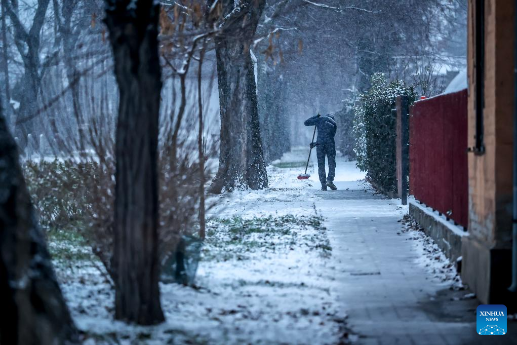 A resident clears snow from a street in Budapest, Hungary on Jan. 5, 2026. (Photo by David Balogh/Xinhua)