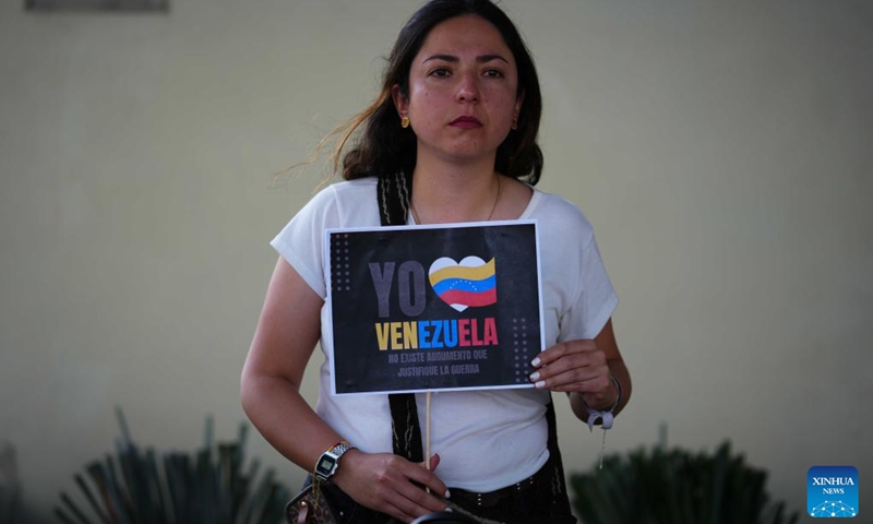 A woman holds a sign during a rally in support of Venezuela outside the U.S. Embassy in Bogota, Colombia, Jan. 3, 2026. The U.S. military launched a series of attacks against Venezuela early Saturday morning, reportedly capturing Venezuelan President Nicolas Maduro and flying him out of the country. (Photo: Xinhua)