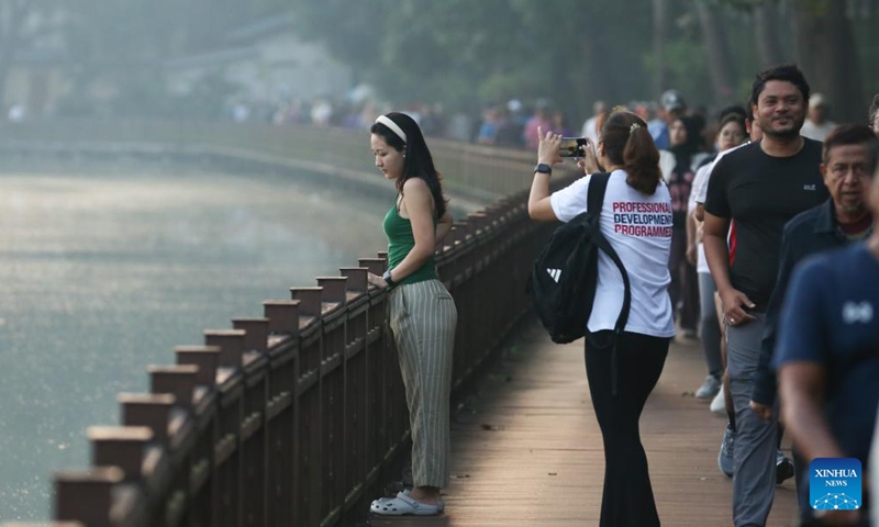 A girl poses for a photo in the early morning near the Kandawgyi lake in Yangon, Myanmar, Jan. 3, 2026. (Photo: Xinhua)
