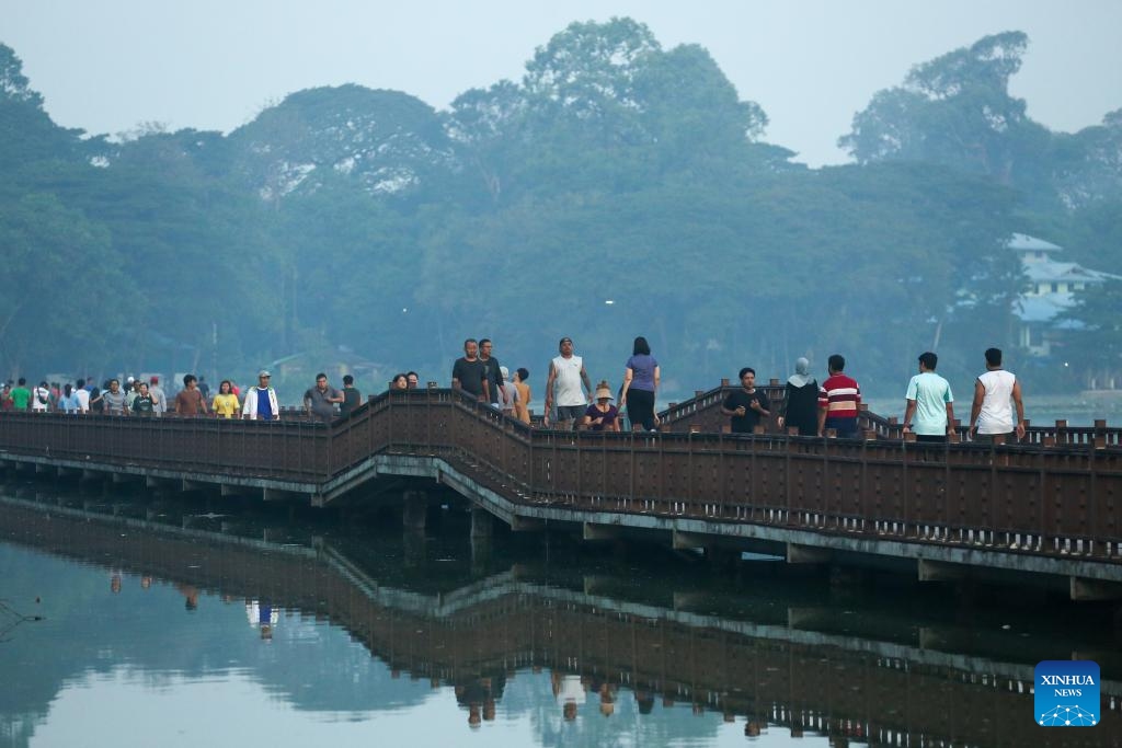People walk at a trestle bridge over Kandawgyi lake in the early morning in Yangon, Myanmar, Jan. 3, 2026. (Photo: Xinhua)