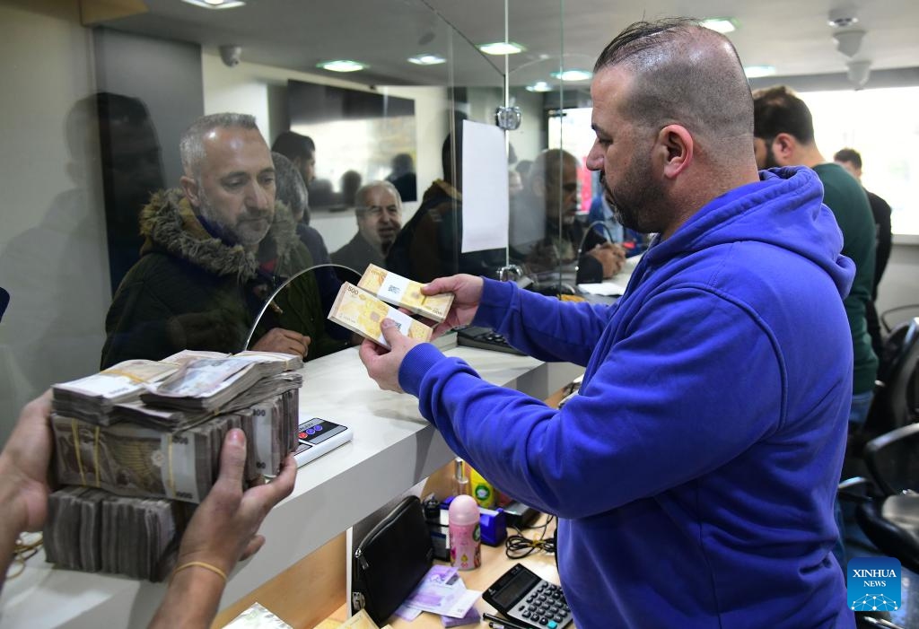 Syrian citizens exchange newly issued Syrian pound banknotes at a designated exchange point in Damascus, Syria, Jan. 4, 2026. Syria has begun circulating its new currency following a nationwide exchange process launched earlier this month. (Photo: Xinhua)