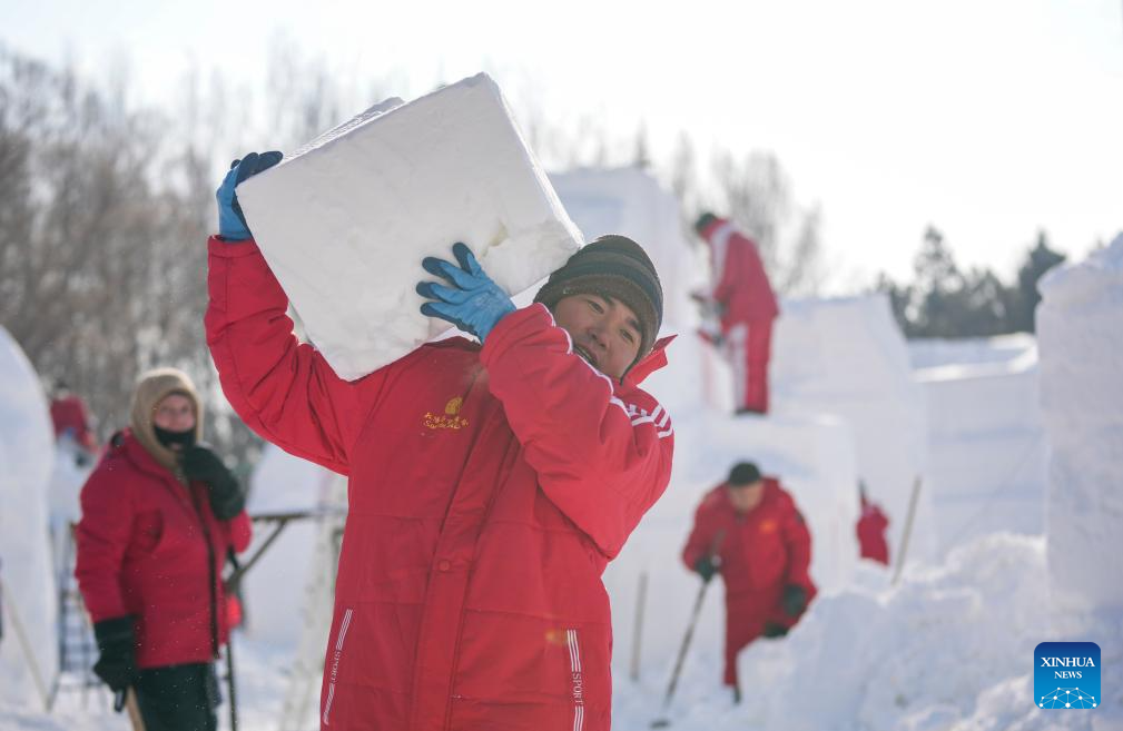 A contestant moves a snow block at the compound for the Sun Island International Snow Sculpture Art Expo in Harbin, northeast China's Heilongjiang Province, Jan. 6, 2026. The 28th Harbin international snow sculpture competition kicked off here on Tuesday, attracting 25 teams of snow sculptors from 13 countries. (Xinhua/Wang Jianwei)