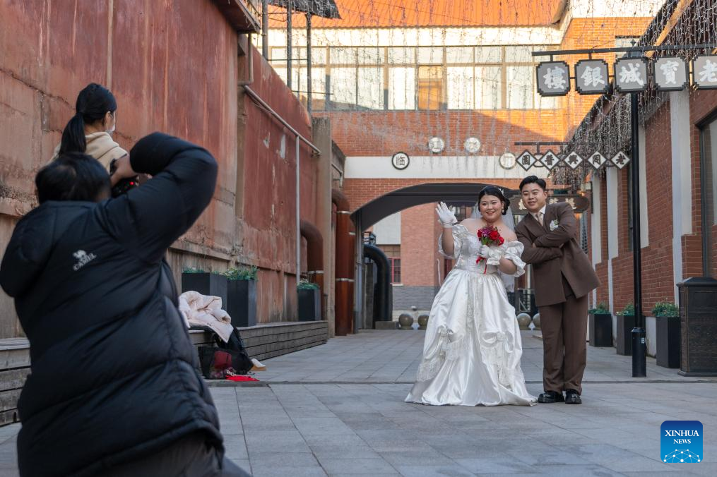 A couple poses for wedding photos at the cultural and creative park of Shashi dock in Jingzhou, central China's Hubei Province, Jan. 7, 2026. In recent years, Jingzhou has continuously conducted the restoration and green development of historic sites. Leveraging the profound history and industrial heritage, Shashi dock here has been transformed into a cultural and creative park integrating cultural exhibitions, riverside tourism, exercise facilities, and innovation bases, which has become a popular leisure destination for citizens. (Xinhua/Du Zixuan)