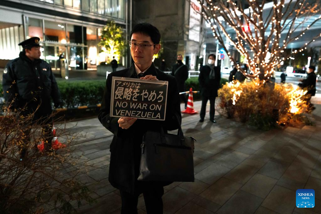 A man holds a slogan in support of Venezuela during a protest in front of the U.S. embassy in Tokyo, Japan, Jan. 6, 2026. The U.S. military struck Venezuela on Saturday, capturing President Maduro and his wife and transferring them to the United States. (Xinhua/Jia Haocheng)