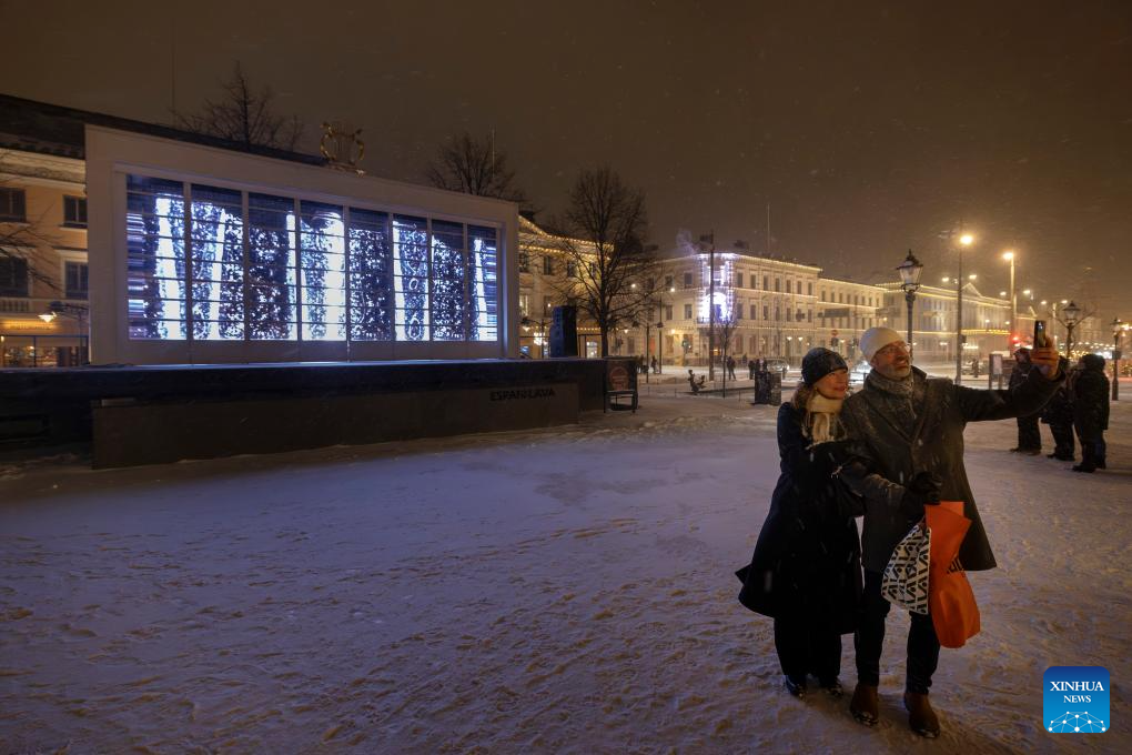 People take selfies in front of a light installation at the light festival in Helsinki, Finland, on Jan. 6, 2026. (Photo by Matti Matikainen/Xinhua)