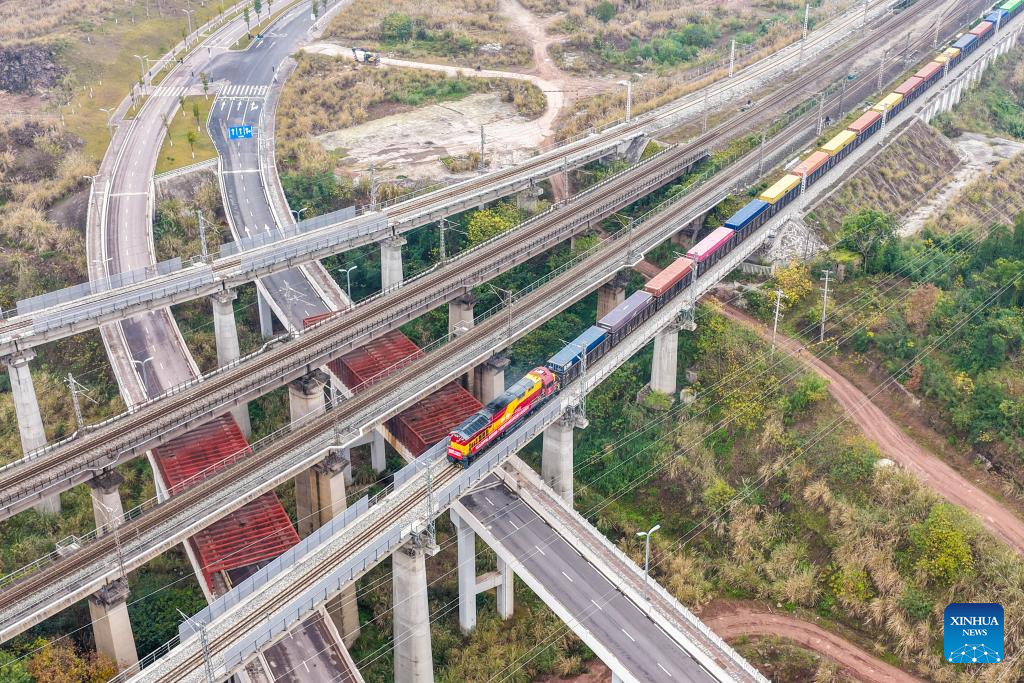 An aerial drone photo taken on Jan. 7, 2026 shows a freight train loaded with Chongqing-manufactured new energy vehicles departing from Yuzui Station at Guoyuan Port in Chongqing, southwest China. Departing on Wednesday, this freight train is expected to arrive at Nansha Port in south China's Guangzhou City after 48 hours and then be transferred to a vessel bound for the Middle East.

As a major vehicle manufacturing base, Chongqing has stably operated eastbound and southbound rail-sea intermodal freight trains via Ningbo, east China's Zhejiang Province and Qinzhou, south China's Guangxi Zhuang Autonomous Region. (Xinhua/Tang Yi)