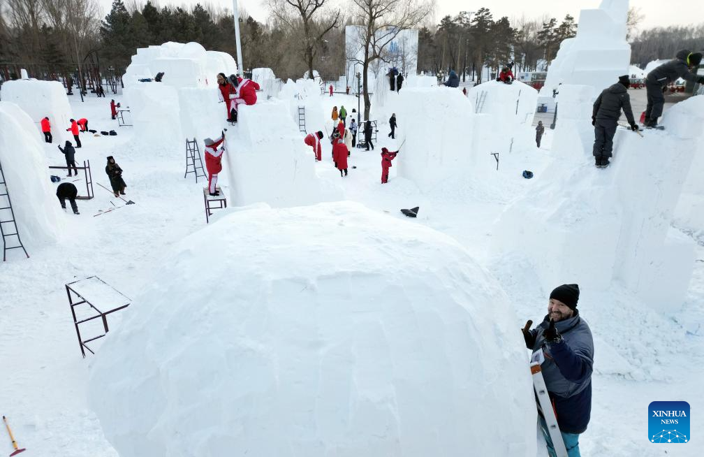 A drone photo shows contestants working on snow sculptures at the compound for the Sun Island International Snow Sculpture Art Expo in Harbin, northeast China's Heilongjiang Province, Jan. 6, 2026. The 28th Harbin international snow sculpture competition kicked off here on Tuesday, attracting 25 teams of snow sculptors from 13 countries. (Photo by Liu Yang/Xinhua)