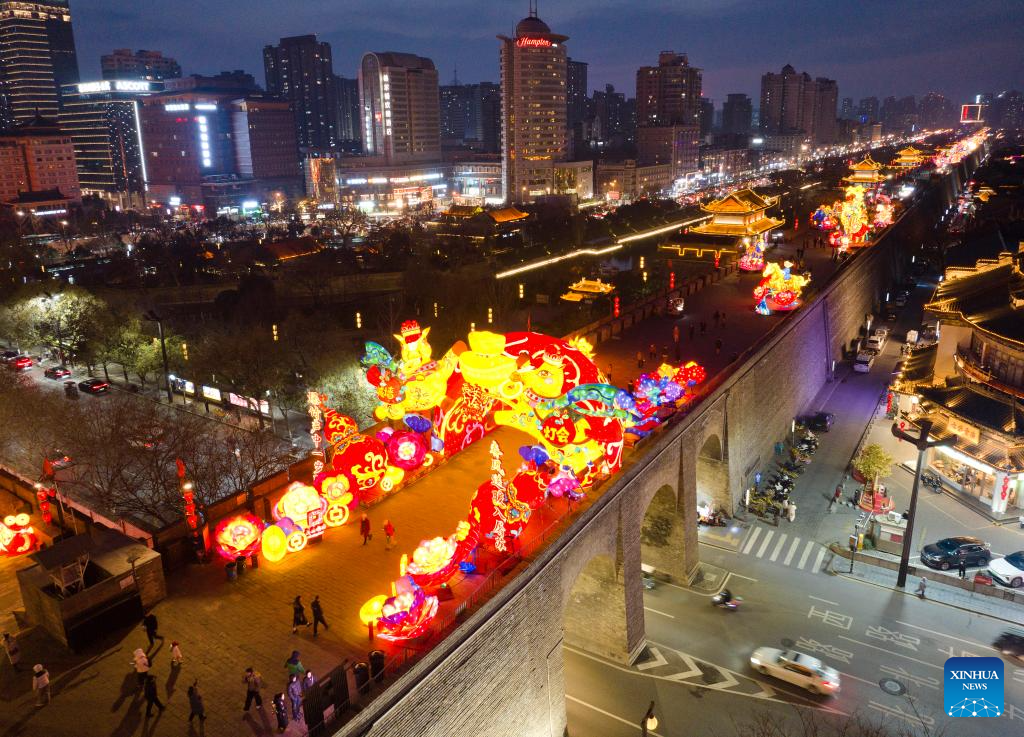 An aerial drone photo taken on Jan. 4, 2026 shows tourists watching lanterns on the ancient city wall of Xi'an during a lantern festival in Xi'an, northwest China's Shaanxi Province. A lantern festival is held here to mark the upcoming Chinese Lunar New Year. (Xinhua/Shao Rui)