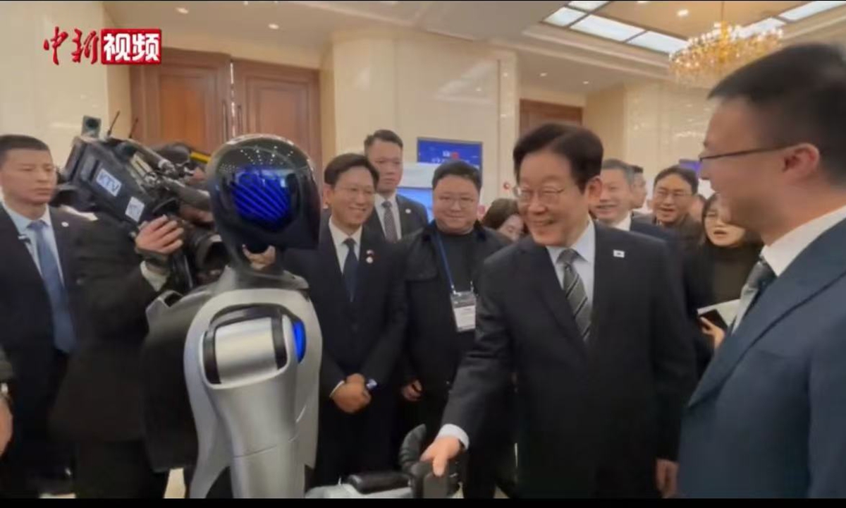 ROK president Lee shakes hands with a Chinese-made humanoid robot at Korea-China Venture Startup Summit in Shanghai: media