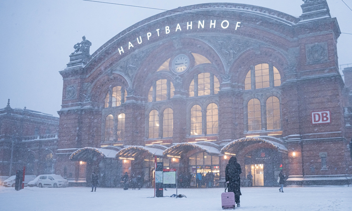 Travelers walk in the snow in front of Bremen Central Station, in Bremen, Germany, on January 9, 2026. Winter Storm Elli swept across large parts of Germany, killing at least three people and severely disrupting transport, schools and public services, particularly in the country's north, Xinhua reported. Photo: VCG