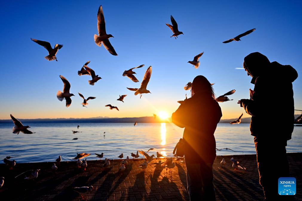 People enjoy sunset by Ohrid Lake in Ohrid, North Macedonia, Jan. 12 2026. (Photo by Tomislav Georgiev/Xinhua)