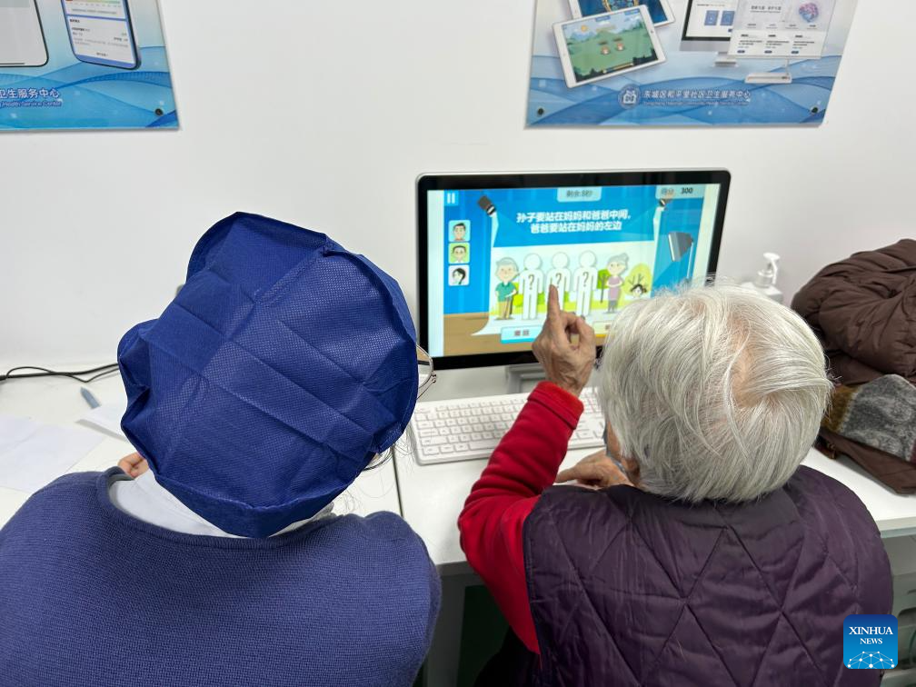 A senior patient receives cognitive training on a computer under the guidance of a staff member at the memory clinic of Hepingli Community Health Service Center in Beijing, capital of China, on Jan. 7, 2026. (Xinhua/Shen Anni)