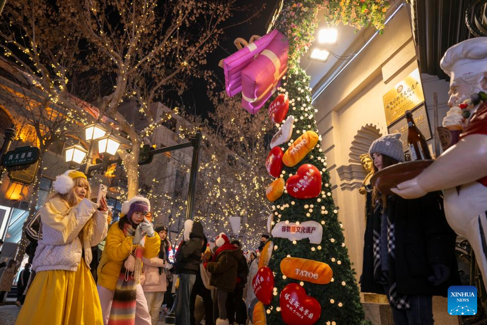 A woman poses for photos on the Central Street in Harbin, northeast China's Heilongjiang Province, Jan. 12, 2026. As one of the most popular attractions in Harbin, the Central Street, which is renowned for its diverse European-style architecture, wows tourists with its colorful lights at night during the city's tourism boom this winter. (Xinhua/Zhang Tao)