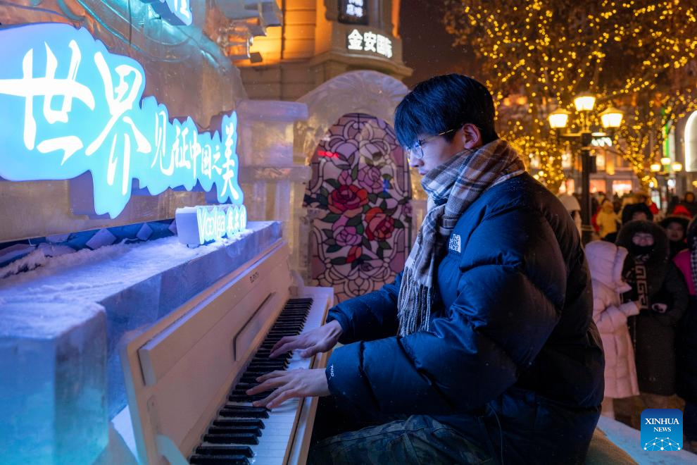 A man plays piano on the Central Street in Harbin, northeast China's Heilongjiang Province, Jan. 12, 2026. As one of the most popular attractions in Harbin, the Central Street, which is renowned for its diverse European-style architecture, wows tourists with its colorful lights at night during the city's tourism boom this winter. (Xinhua/Zhang Tao)