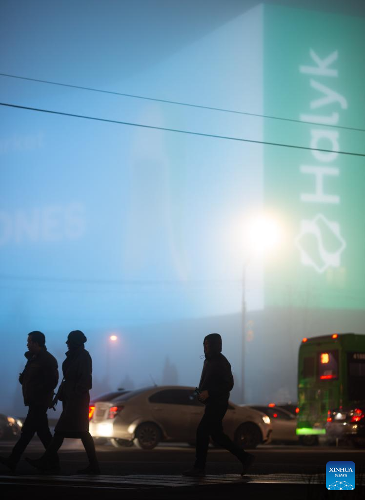 Pedestrians cross the street in heavy fog in Almaty, Kazakhstan, on Jan. 13, 2026. (Xinhua/Li Renzi)