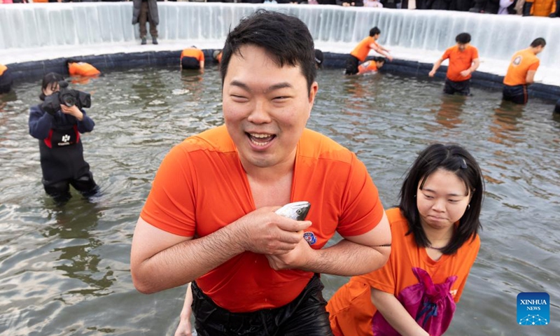 A man catches fish with bare hands during the Hwacheon Sancheoneo Ice Festival in Hwacheon-gun, South Korea, Jan. 10, 2026. (Photo: Xinhua)