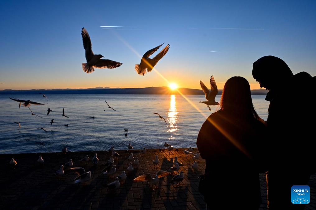 People enjoy sunset by Ohrid Lake in Ohrid, North Macedonia, Jan. 12 2026. (Photo by Tomislav Georgiev/Xinhua)