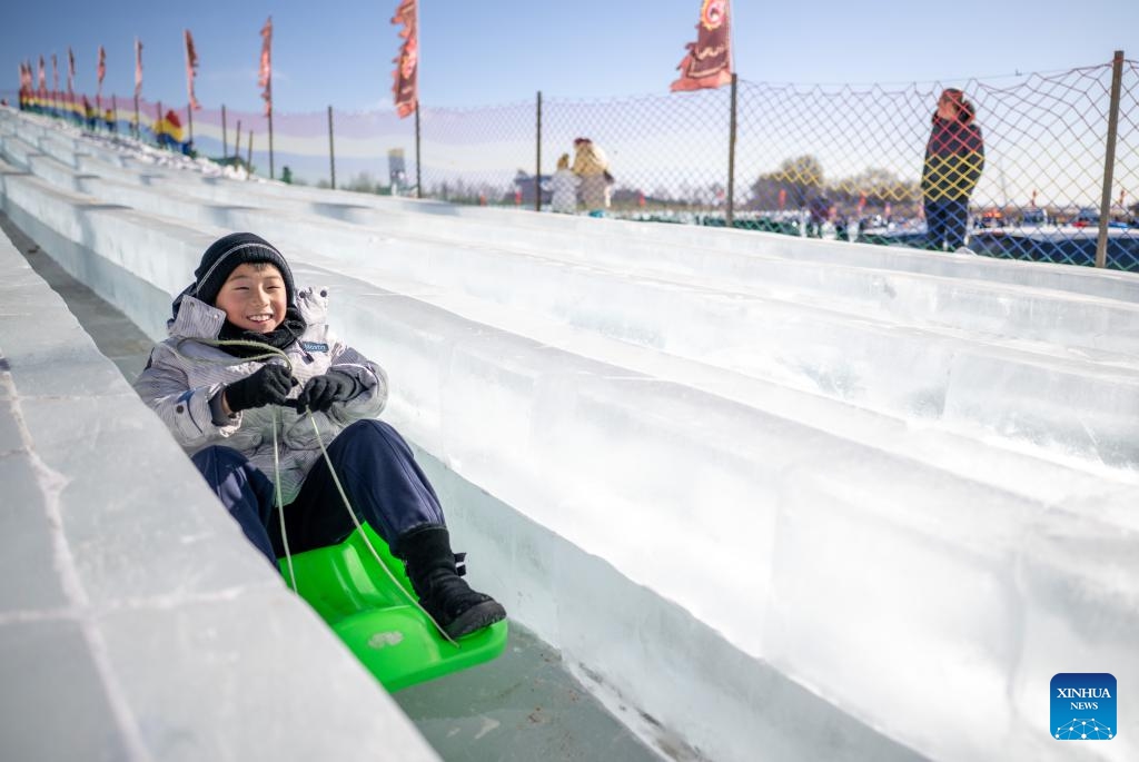 A boy enjoys ice slide during the 4th Hasuhai Lake winter fishing festival in Tumd Left Banner of Hohhot, north China's Inner Mongolia Autonomous Region, Jan. 10, 2026. The 4th Hasuhai Lake winter fishing festival opened in Tumd Left Banner of Hohhot on Saturday. The activity features ice and snow entertainment, hot spring experience, delicious food and folk shows, attracting many citizens and tourists. (Photo: Xinhua)