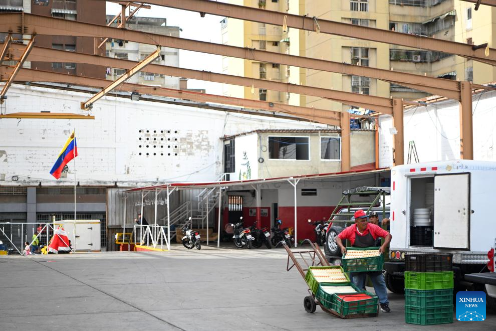 A man moves cheese at a cheese market in Caracas, Venezuela, Jan. 13, 2026. (Xinhua/Ding Hongfa)