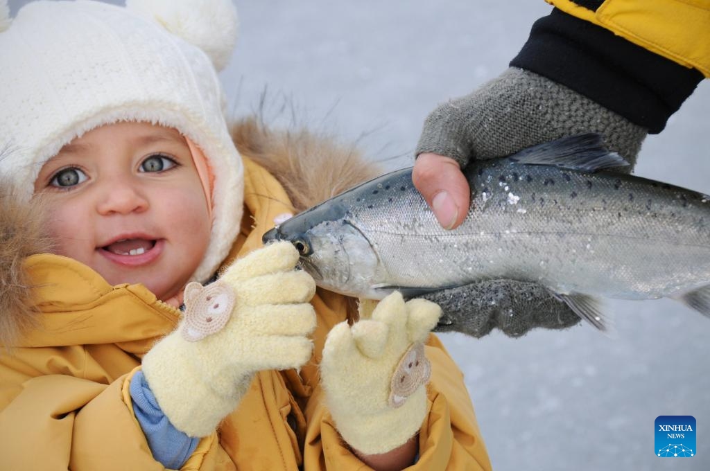 A kid holds a fish during the Hwacheon Sancheoneo Ice Festival in Hwacheon-gun, South Korea, Jan. 10, 2026. (Photo: Xinhua)
