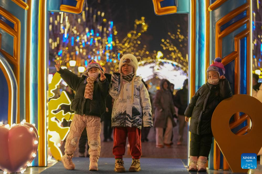 Children have fun on the Central Street in Harbin, northeast China's Heilongjiang Province, Jan. 11, 2026. As one of the most popular attractions in Harbin, the Central Street, which is renowned for its diverse European-style architecture, wows tourists with its colorful lights at night during the city's tourism boom this winter. (Xinhua/Wang Jianwei)