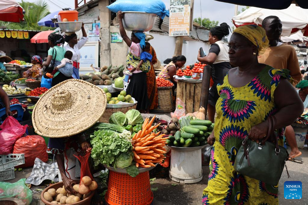 A woman walks past a vegetable stall at a street market in Accra, Ghana, on Jan. 14, 2026. (Photo by Seth/Xinhua)