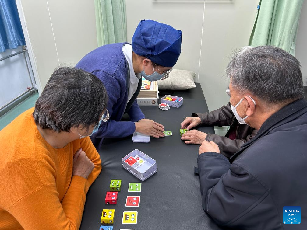 Senior patients play puzzles under a staff member's guidance at the memory clinic of Hepingli Community Health Service Center in Beijing, capital of China, on Jan. 7, 2026. (Xinhua/Shen Anni)