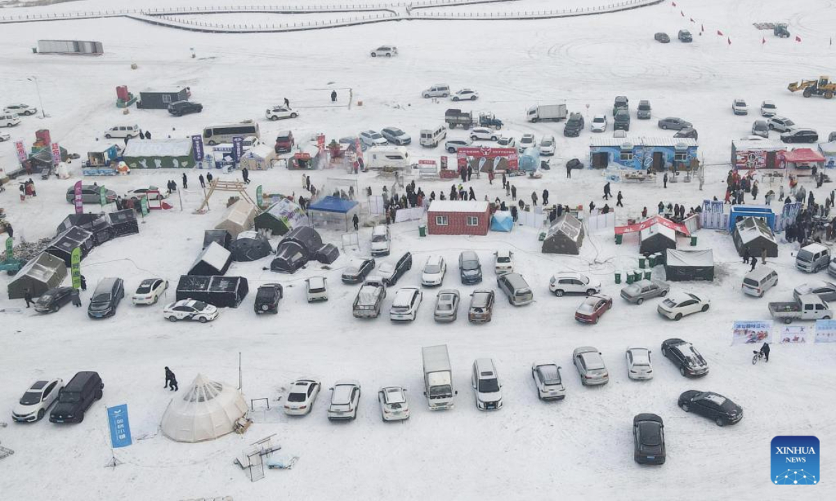 An aerial drone photo taken on Jan. 12, 2026 shows tourists visiting a village fair during a camping festival in Qiqihar City, northeast China's Heilongjiang Province. The week-long camping festival opened here on Monday, where camping enthusiasts and tourists across China are allowed to experience the unique charm of camping and local folk customs in frigid chilliness. (Photo by Li Nan/Xinhua)