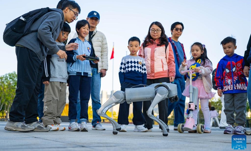 A child learns to operate a robotic dog at the University of Macao in Macao, south China, Jan. 11, 2026. The launch ceremony for the celebrations of the 45th anniversary of the University of Macao, along with an open-day event, kicked off here on Sunday. (Xinhua/Cheong Kam Ka)