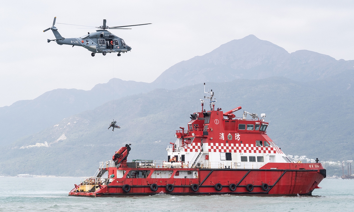 A helicopter from the Hong Kong Special Administrative Region (HKSAR) Government Flying Service and vessels from the HKSAR Fire Services Department collaborate to transfer a survivor rescued from the sea near Mong Tung Wan, Hong Kong, on January 12, 2026, during a short-range search and rescue exercise conducted by the HKSAR Government Civil Aviation Department. Photo: VCG